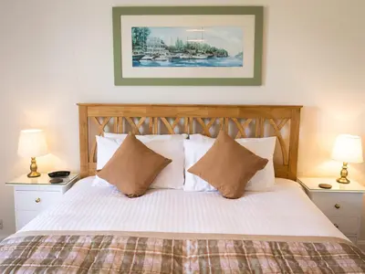 a bedroom with a bed with white sheets and pillows at Pengelly Farmhouse B&B in Truro