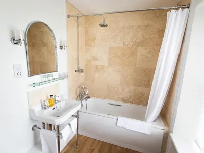 a bathroom with a tub and a sink and a shower at Pengelly Farmhouse B&B in Truro