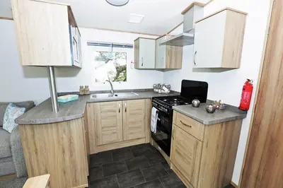a small kitchen with a sink and a stove at Newperran Holiday Resort in Newquay
