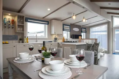 a kitchen with a table with glasses of wine at Newperran Holiday Resort in Newquay