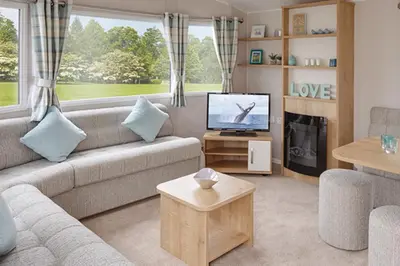 a living room with a couch and a tv at Newperran Holiday Resort in Newquay