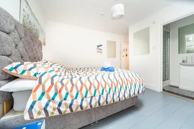 a bedroom with a large bed and a sink at Palace Guesthouse in Newquay