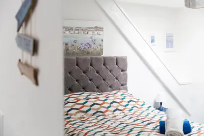 a bedroom with a bed and a painting on the wall at Palace Guesthouse in Newquay