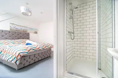 a small bedroom with a bed and a shower at Palace Guesthouse in Newquay