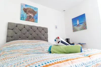 a bedroom with a bed with two paintings on the wall at Palace Guesthouse in Newquay