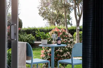 a table with two chairs and a bottle of wine at Gyllyngvase House in Falmouth