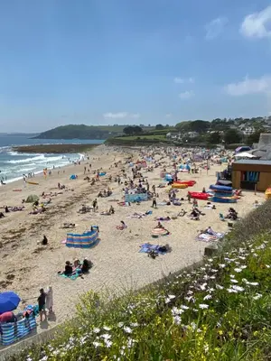 a crowd of people on a beach near the ocean at Gyllyngvase House in Falmouth