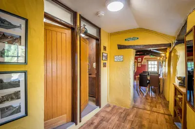 a hallway with yellow walls and a dining room at St. Tinney Farm in Bude