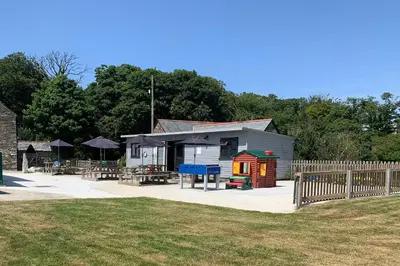 a small building with a playground in front of it at St. Tinney Farm in Bude