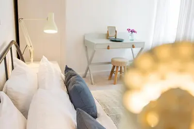 a living room with a couch with pillows and a desk at Cornish Cottage - Truro City Centre in Truro