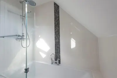 a bathroom with a shower with a glass door at Rosemorran Holiday Apartments in St Ives
