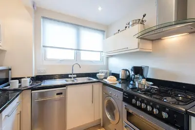 a kitchen with a stove and a dishwasher at Rosemorran Holiday Apartments in St Ives