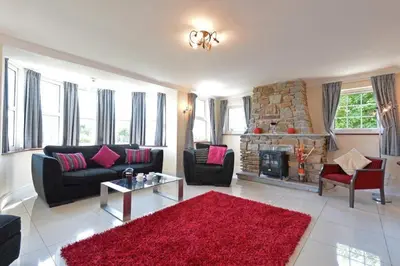 a living room with a couch and a fireplace at Rosemorran Holiday Apartments in St Ives