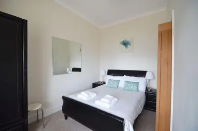 a bedroom with a bed with two pillows and a mirror at Rosemorran Holiday Apartments in St Ives