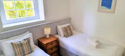 two twin beds in a room with a window at Tregenna Castle Resort in St Ives