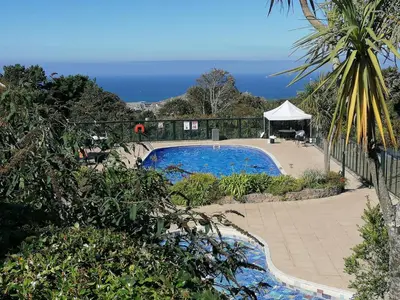 a swimming pool with a table and a gazebo at Tregenna Castle Resort in St Ives