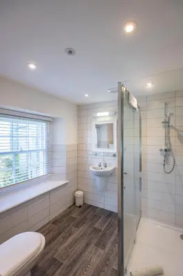 a bathroom with a shower toilet and a sink at Tregenna Castle Resort in St Ives
