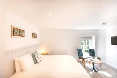 a bedroom with a bed and a table and chairs at Tregenna Castle Resort in St Ives