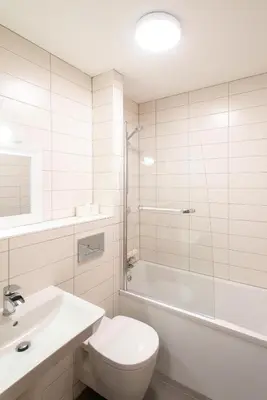 a white bathroom with a toilet and a sink at Tregenna Castle Resort in St Ives