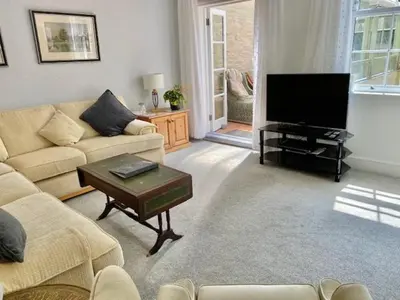 a living room with a couch and a flat screen tv at WE ARE UNIQUE ! 4 min walk to Beach, Pubs, Restaurants, Shops, Htd Pool, Hottub, Games rm, 1 acre Garden, BBQ's Coast to Coast cycle path, Beautiful, Bassets acre, Only six 1-3 bedroom SUPERB apartments, Free Parking and WIFI in Portreath