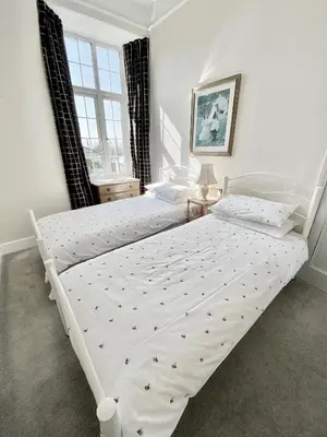 a white bed in a bedroom with a window at WE ARE UNIQUE ! 4 min walk to Beach, Pubs, Restaurants, Shops, Htd Pool, Hottub, Games rm, 1 acre Garden, BBQ's Coast to Coast cycle path, Beautiful, Bassets acre, Only six 1-3 bedroom SUPERB apartments, Free Parking and WIFI in Portreath