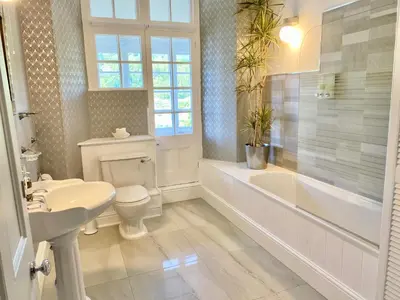 a white bathroom with a tub and a toilet and a sink at WE ARE UNIQUE ! 4 min walk to Beach, Pubs, Restaurants, Shops, Htd Pool, Hottub, Games rm, 1 acre Garden, BBQ's Coast to Coast cycle path, Beautiful, Bassets acre, Only six 1-3 bedroom SUPERB apartments, Free Parking and WIFI in Portreath