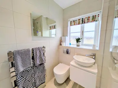 a white bathroom with a toilet and a sink at Lanhydrock View in Bodmin