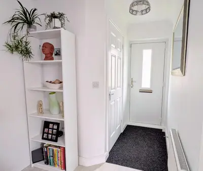 a hallway with white shelves and a white door at Lanhydrock View in Bodmin