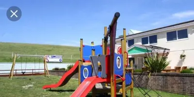 a playground with a slide in a yard at Take me to the beach at J&S caravan holidays Newquay Bay resort in Saint Columb Minor