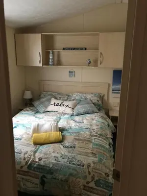 a bedroom with a bed in a small room at Take me to the beach at J&S caravan holidays Newquay Bay resort in Saint Columb Minor