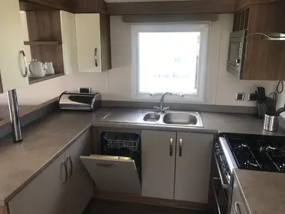 a small kitchen with a sink and a window at Par Sands Coastal Holiday park in Par