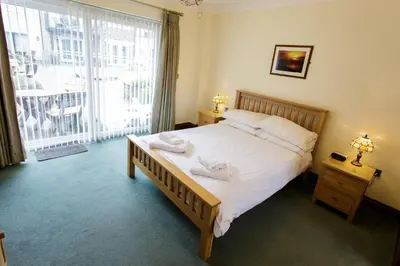 a bedroom with a large bed with two towels on it at Porth Veor Manor Villas & Apartments in Newquay