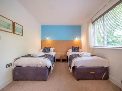 a room with two beds and a desk and a window at Holiday Home Villa Gallery by Interhome in Perranwell