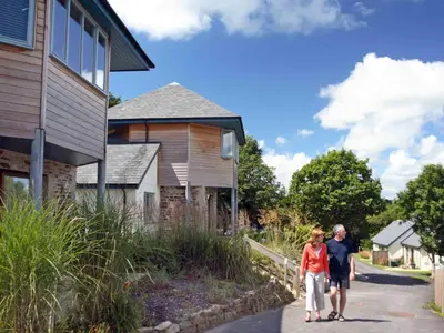 a man and a woman walking down a sidewalk next to a house at Holiday Home Villa Gallery by Interhome in Perranwell