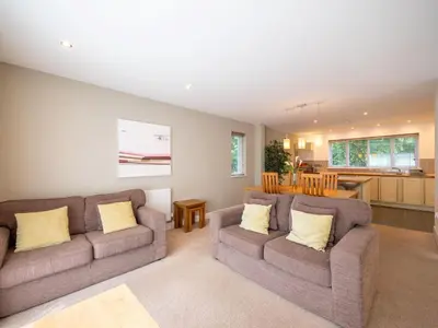 a living room with two couches and a kitchen at Holiday Home Villa Gallery by Interhome in Perranwell