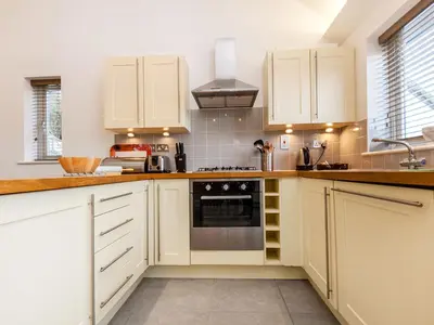 a kitchen with white cabinets and a stove top oven at Holiday Home Villa Gallery by Interhome in Perranwell
