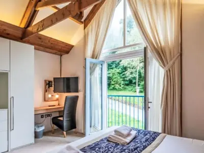 a bedroom with a bed and a desk and a window at Holiday Home Haven by Interhome in Perranwell