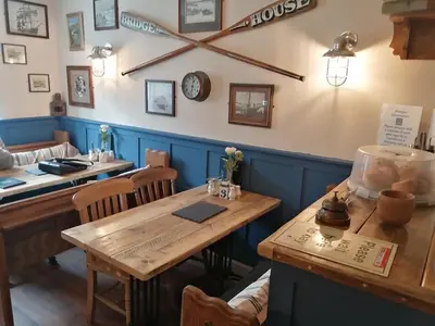 a dining room with a table and chairs and a clock at Bridge House Bed & Breakfast in Boscastle