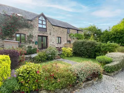 a brick house with a garden in front of it at Haybarn in Fowey