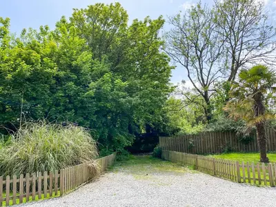 a fence in front of a yard with trees at Haybarn in Fowey