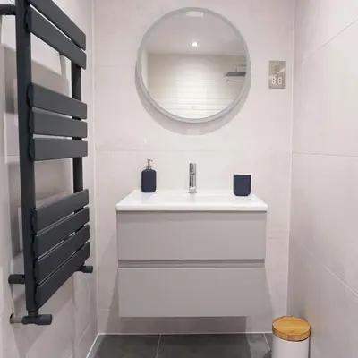 a bathroom with a white sink and a mirror at Saltwater Suites at Fistral in Newquay