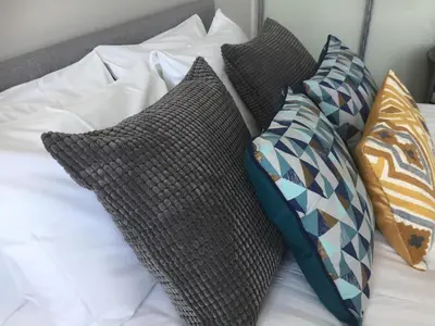 a bed with four pillows on top of it at Saltwater Suites at Fistral in Newquay