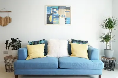 a blue couch with yellow pillows in a living room at Saltwater Suites at Fistral in Newquay