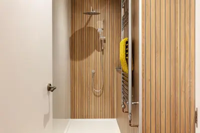 a shower stall in a bathroom with a shower curtain at Chelsea House Holiday Apartments in Falmouth