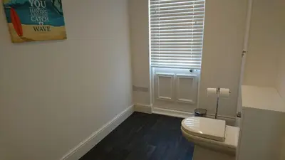 a bathroom with a toilet and a window at Tippy's Guesthouse in Newquay