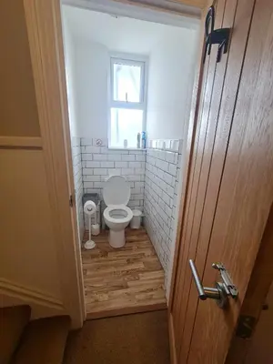 a small bathroom with a toilet and a window at Tippy's Guesthouse in Newquay