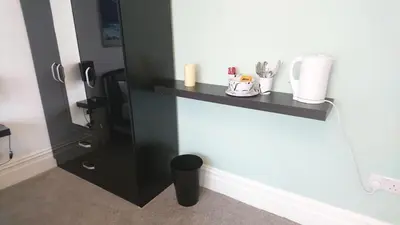 a black shelf on the wall in a room at Tippy's Guesthouse in Newquay