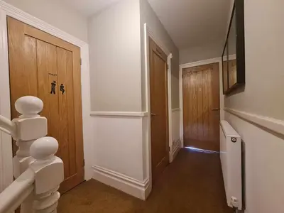 a hallway with a staircase and a door in a house at Tippy's Guesthouse in Newquay