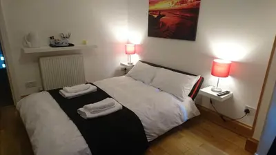 a bedroom with a bed with two towels on it at Tippy's Guesthouse in Newquay