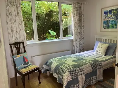 a small bedroom with a bed and a window at Fuchsia Cottage in Porthallow